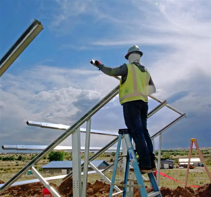 Worker installing ground mount solar racking